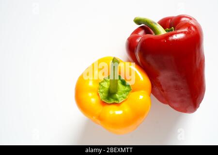 A whole red and yellow pepper on a plain white background Stock Photo