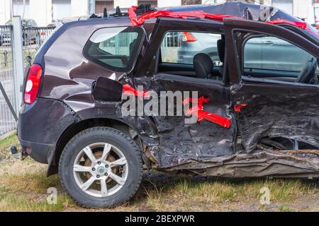 Wrecked crumpled car from the right side after a severe accident with a distorted body and broken windows, after a powerful impact side back view Stock Photo