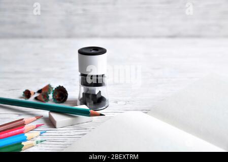 Pencils, notepad, sharpener, eraser and shavings from pencils on a gray non-uniform background Stock Photo