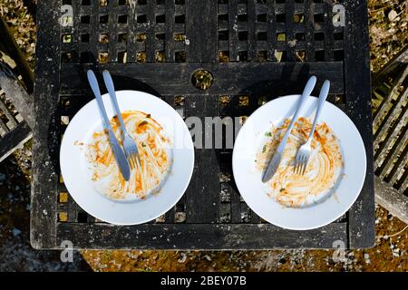 Two empty dirty plates with cutlery Stock Photo