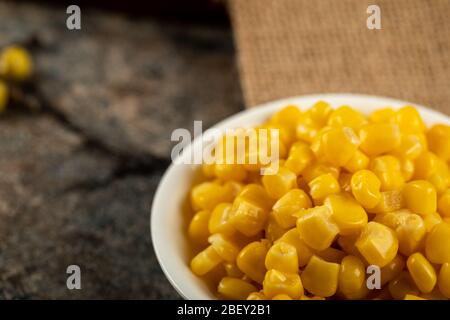 Marinated corn seeds in a white saucer Stock Photo