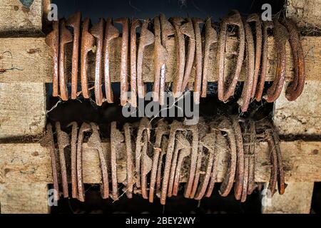 Old rusty horseshoes hang on a pole. Iceland Stock Photo