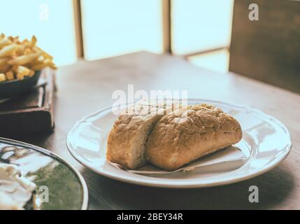 Ciabatta in white plate on wooden table Stock Photo