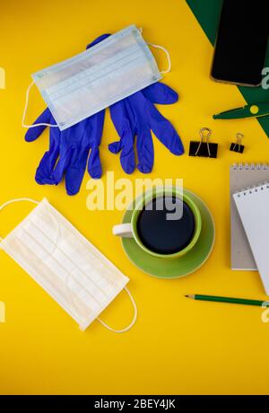 Working at home. Medical mask on the desktop. Remote work and study. Telework, freelance. Notepad with place for text and pen for notes. Layout Stock Photo