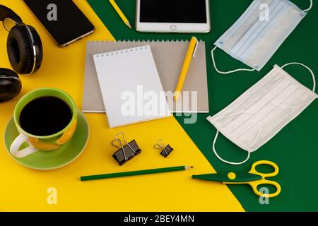 Working at home. Medical mask on the desktop. Remote work and study. Telework, freelance. Notepad with place for text and pen for notes. Layout Stock Photo