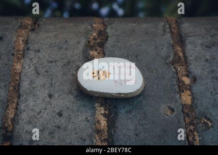 London, UK - April 12, 2020: Pebble painted with thank you NHS message left on the street as people express gratitude towards NHS staff during lockdow
