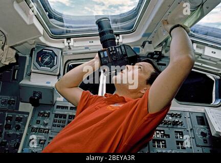 (6-10 Oct 1990) ---  Astronaut Robert D. Cabana, STS-41 pilot, uses a handheld camera to  record Earth scenes from the aft flight deck of Discovery. Stock Photo