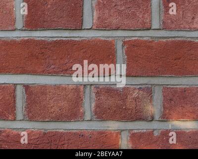 Close up of coarse red brickwork with grey mortar Stock Photo