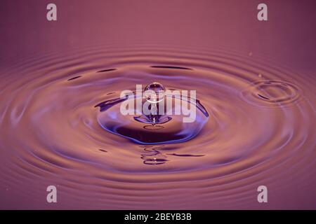 Splash of water crown on red surface Stock Photo