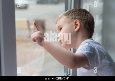 Cute 4  Years Old Boy Looking Through The Window and smiling Stock Photo