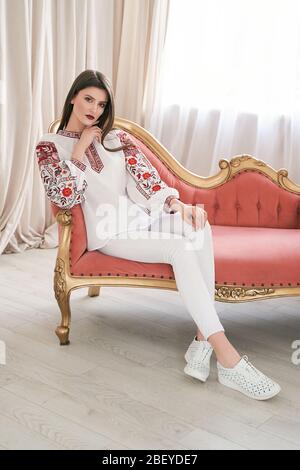 Young beautiful brunette girl wearing gorgeous ethnic style embroidered shirt, modern derivative from traditional Ukrainian vyshyvanka, one of the mai Stock Photo
