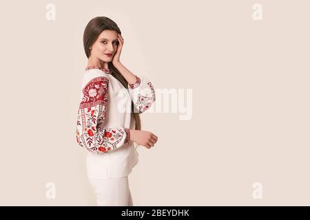 Young beautiful brunette girl wearing gorgeous ethnic style embroidered shirt, modern derivative from traditional Ukrainian vyshyvanka, one of the mai Stock Photo