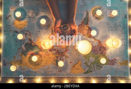 Top view female hands planning vacation tour equipped with world map and vintage nautical compass - Travel adventure lifestyle people Stock Photo