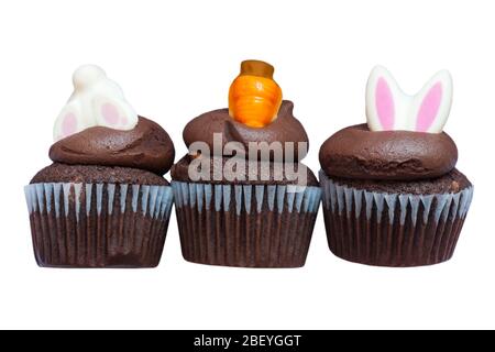 M&S Easter Cupcakes isolated on white background - three 3 mini chocolate cupcakes with chocolate buttercream and Easter decorations Stock Photo
