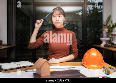 Female architect working with new startup project and thinking about her project at home office. Stock Photo