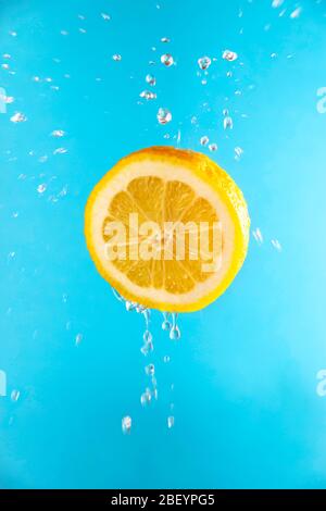 Yellow lemon in flight with drops of juice Stock Photo