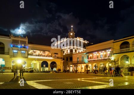 Tourists sitting out at nighttime enjoying dining out in restaurants and cafes in Plaza Vieja, Havana old town, Cuba Stock Photo