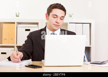 Young businessman in a suit works on the computer Stock Photo