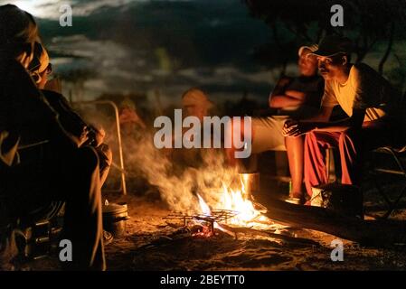 Jo/hoansi men gather around the fire and tell stories in Nyae Nyae, Namibia. Stock Photo