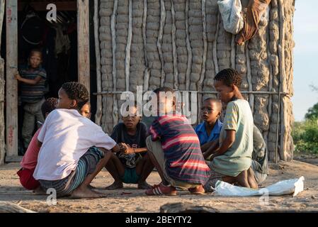 Young Ju/hoansi boys gather to eat breakfast in Nyae Nyae, Namibia. Stock Photo