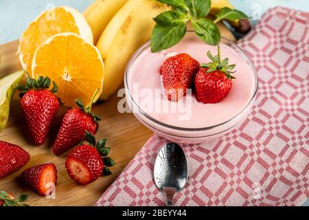 A bowl of pudding with strawberry aroma with fruits on it, served with fresh fruits Stock Photo