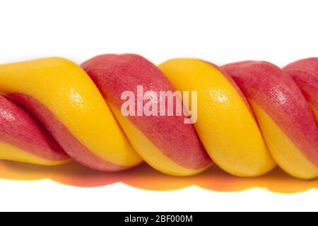 Bright, tasty, sweet and striped lollipop on a stick of red and yellow in the form of a spiral isolated on a white background Stock Photo