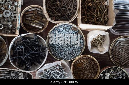 Various hardware, nails, screws and bolts in boxes. Home workshop. Top view Stock Photo