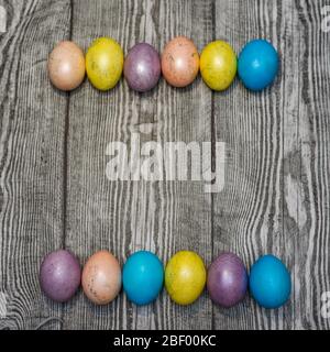 Many multi colored easter eggs on the wooden background. Space for text. Stock Photo