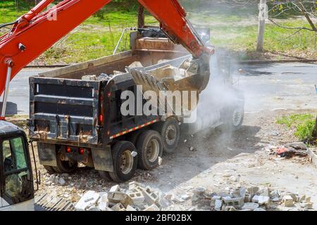 Excavator scoop truck loading a construction waste into reinforced concrete full recycling garbage Stock Photo