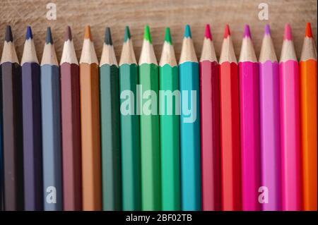 Close-up view of  rainbow colored pencils on natural wood background Stock Photo