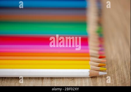 Close-up view of  rainbow colored pencils on natural wood background Stock Photo