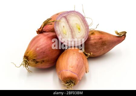 Vegetables: several isolated shallots, one cut in half on a white background Stock Photo