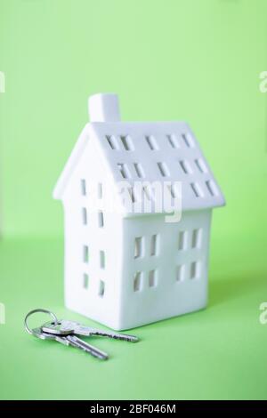 A miniature house with key isolated on a green background Stock Photo