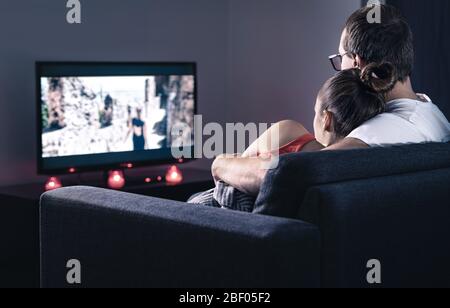 Couple watching movie or series. Online streaming and VOD service in tv screen. Film stream or television show. Stock Photo