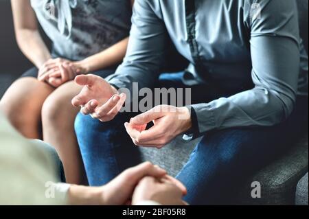 Couple counseling or therapy session. Man talking about problems in the family. Husband and wife meeting their psychiatrist. Stock Photo