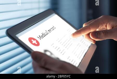 Medical record in electronic form. Digital EMR with patient health care information. Doctor using tablet in hospital or clinic. Stock Photo