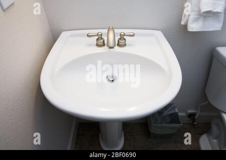 Simple, clean, white bathroom pedastal sink and faucet Stock Photo