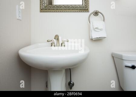 Simple, clean, white bathroom pedastal sink and faucet Stock Photo