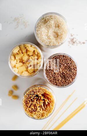 Various pasta and cereal grains in a plastic jars for a long storage. Stock Photo