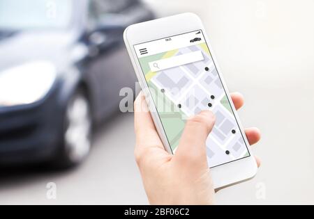 Car or ride share mobile app in smartphone. Carsharing, ridesharing or carpool service. Sharing economy concept. Person ordering taxi online. Stock Photo