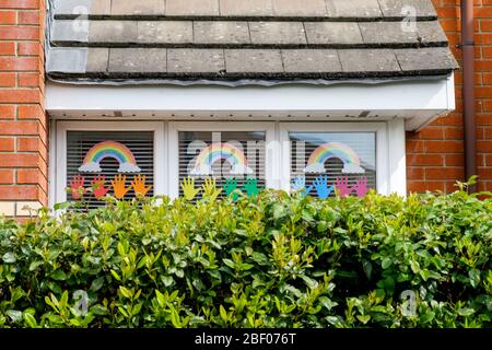 Chippenham, Wiltshire UK, 16th April, 2020. With the nation due to once again clap to show their support for the NHS tonight, a childs rainbow drawings (a symbol of support for people wanting to show solidarity with NHS workers) are pictured in a front window of a home in Chippenham, Wiltshire. Credit: Lynchpics/Alamy Live News Stock Photo