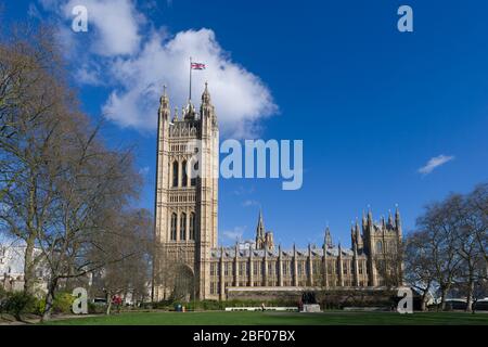 A Union Jack flag flying from, The Victoria Tower, Palace of Westminster commonly known as the Houses of Parliament, which is the meeting place of the Stock Photo