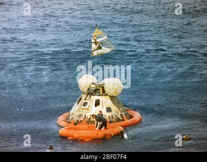 Astronaut John L. Swigert Jr., command module pilot, is lifted aboard a helicopter in a Billy Pugh helicopter rescue net while astronaut James A. Lovell Jr., commander, awaits his turn. The crew was taken to the U.S.S. Iwo Jima, prime recovery ship, several minutes after the Apollo 13 spacecraft splashed down at 12:01:44 pm CST on April 17, 1970. Stock Photo