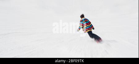 Speed feeling. Fast motion effect. Freeride snowboarder rides his board on the mountain. Winter season. Place for text Stock Photo