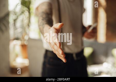 Close up of male hand greeting, welcoming somebody. Education, freelance, business and communication concept. Caucasian male model indoors inviting, showing. Stock Photo