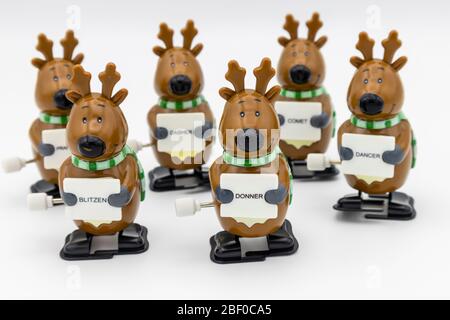 Group of six novelty plastic wind-up models of Santa's reindeer holding signs with their names Stock Photo