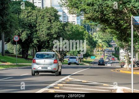 Campo Grande - MS, Brazil - March 30, 2020: Traffic of cars at Afonso Pena avenue, the main avenue of the city surrounded by big trees and large stree Stock Photo