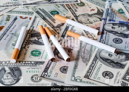 Concept of smoking cost. Cigaretes on a dollars background. Stock Photo