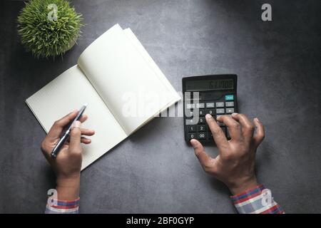 accountant using calculator and financial chart on table  Stock Photo