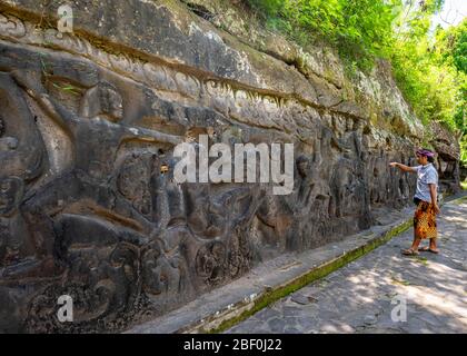 Horizontal portrait of a local tour guide at Yeh Pulu Relief in Bali, Indonesia. Stock Photo